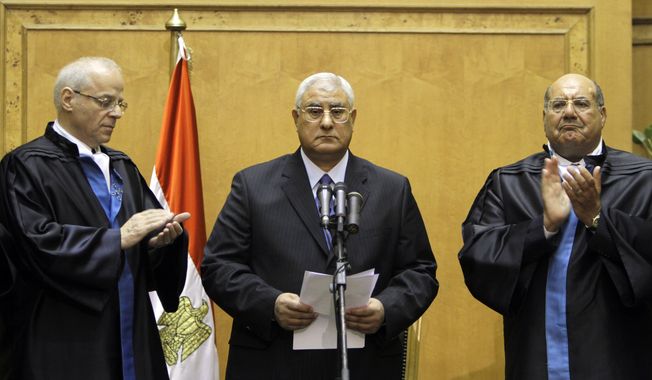 Egypt&#x27;s chief justice Adly Mansour, center, is applauded by chiefs of the constitutional court after he is sworn in as the nation&#x27;s interim president Thursday, July 4, 2013. The chief justice of Egypt&#x27;s Supreme Constitutional Court was sworn in Thursday as the nation&#x27;s interim president, taking over hours after the military ousted the Islamist President Mohammed Morsi. (AP Photo/Amr Nabil)