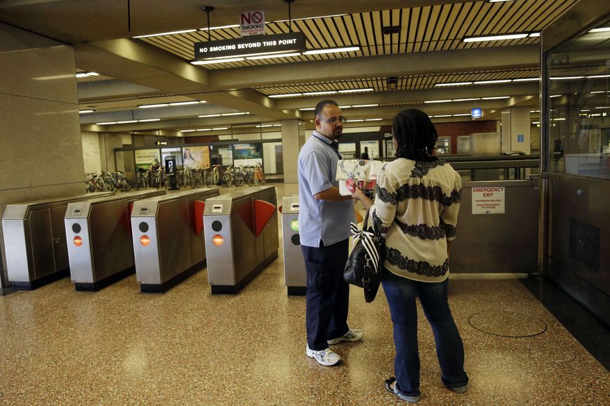 ** FILE ** BART station agent Mark Madrigal helps a customer at the Lake Merritt station in Oakland, Calif., Friday, June 28, 2013. (AP Photo/Marcio Jose Sanchez)