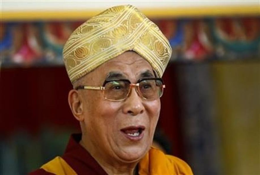 Tibetan spiritual leader the Dalai Lama gestures after he was presented the traditional headgear during an event organized to celebrate his 78th birthday at a Tibetan Buddhist monastery in Bylakuppe, about 137 miles southwest of Bangalore, India, Saturday, July, 6, 2013. (Associated Press)