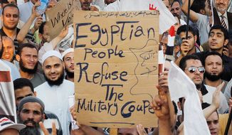 Members of the Muslim Brotherhood and other supporters of ousted President Mohammed Morsi protest near Cairo University on Sunday as tensions mount between Islamists and the U.S.-backed secular military. (Associated Press)