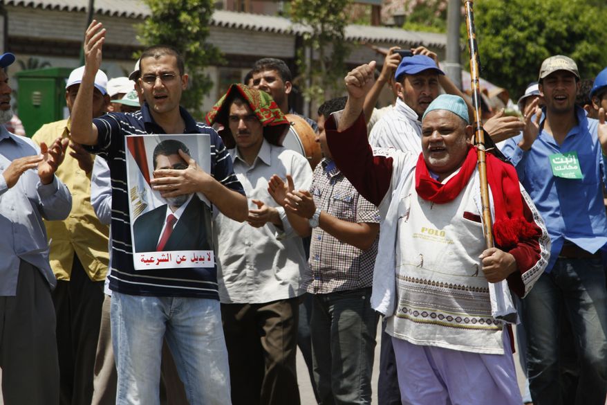 Supporters of ousted Egyptian President Mohammed Morsi chant slogans at a sit-in in Nasser City, a suburb of Cairo, on Sunday, July 7, 2013. (AP Photo/Paul Schemm)
