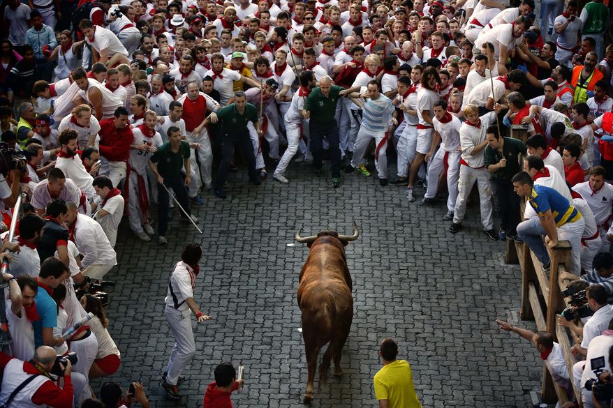 A fighting bull runs toward revelers during the running of the bulls at the San Fermin festival in Pamplona, Spain, on Sunday, July 7, 2013. Revelers from around the world arrive in the city every year to take part on some of the eight days of the running of the bulls, glorified by Ernest Hemingway's "The Sun Also Rises." (AP Photo/Daniel Ochoa de Olza)