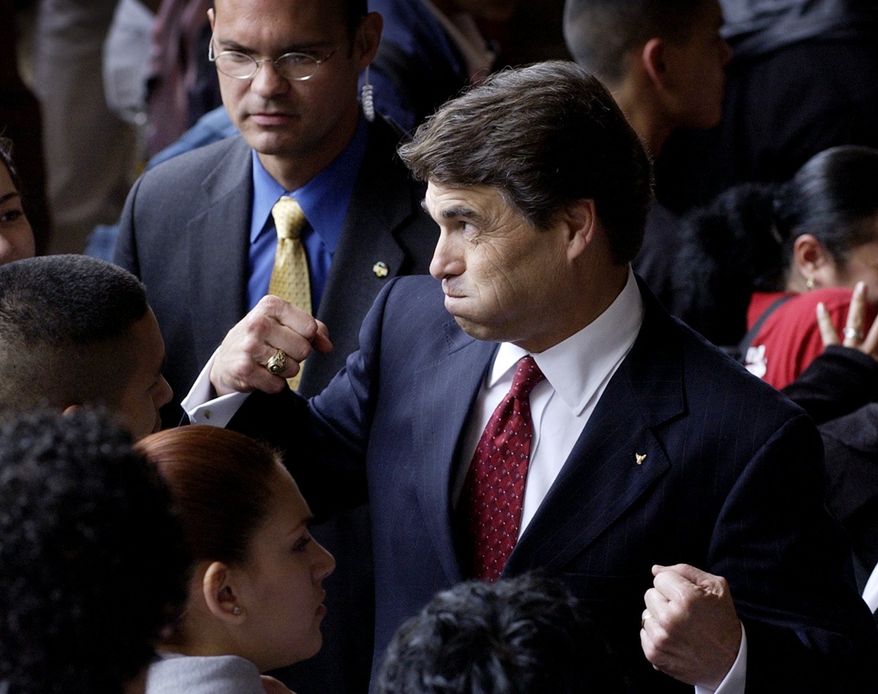 ** FILE ** In this April 8, 2004, file photo, Texas Gov. Rick Perry makes a face and flexes his muscles as he talks with students at Fox Tech High School following the announcement of his school finance proposal in San Antonio. Perry announced Monday, July 8, 2013, that he would not seek re-election as Texas governor next year. (AP Photo/Eric Gay, File)