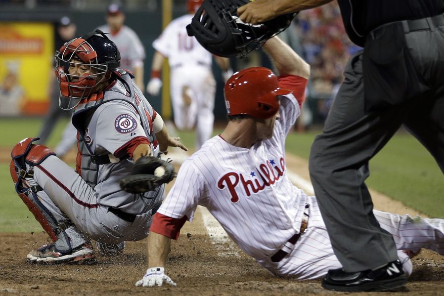 Kurt Suzuki tries to get Chase Utley out on a plate at the plate in the eighth inning but he is just late with the tag. The Nationals lost to the Phillies 3-1. (Associated Press photo)