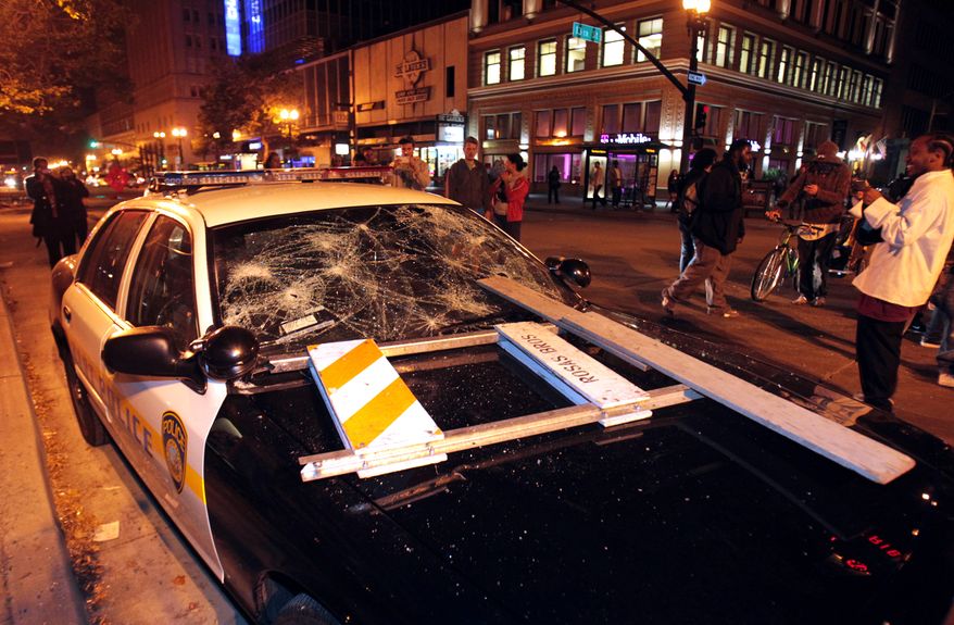 A BART police vehicle is vandalized early on Sunday, July 14, 2013, in Oakland, Calif., during a protest after George Zimmerman was found not guilty in the 2012 shooting death of teenager Trayvon Martin. Protesters angered by the verdict held largely peaceful demonstrations in three California cities but broke windows and started small street fires Oakland, police said. (AP Photo/Bay Area News Group, Anda Chu)