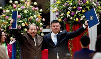 Nicaraguan President Daniel Ortega and Wang Jing display an agreement granting the Chinese businessman the exclusive right to develop a multibillion-dollar waterway to rival the Panama Canal. Construction is set to be completed by 2019, Mr. Wang said. (Associated Press)