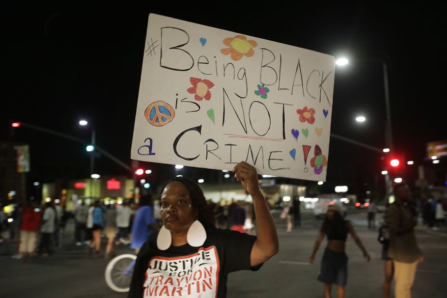 A woman holds up a sign during a demonstration in reaction to the acquittal of neighborhood watch volunteer George Zimmerman on Monday, July 15, 2013, in Los Angeles. (AP Photo/Jae C. Hong)