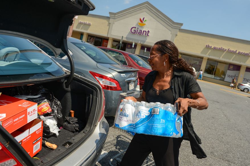 Phebie Warren, the director of the Little Busy Bee day care center in Ft. Washington, Md., loads her trunk with bottled water as a large portion of Prince George's County will be without water for the next 3-5 days as the Washington Suburban Sanitary Commission prepares to repair a 54-inch water line which is close to bursting, Ft. Washington, D.C., Tuesday, July 16, 2013. (Andrew Harnik/The Washington Times)