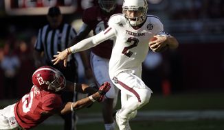 FILE - In this Nov. 10, 2012 file photo, Texas A&amp;M quarterback Johnny Manziel (2) runs through the tackle of Alabama defensive back Deion Belue (13) during the first half of an NCAA college football game at Bryant-Denny Stadium in Tuscaloosa, Ala. (AP Photo/Dave Martin, File)