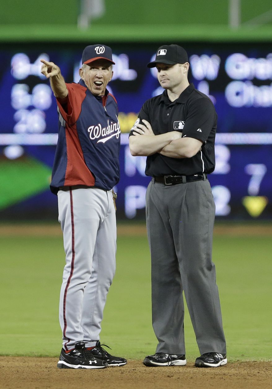 Washington Nationals manager Davey Johnson, left, argues a call with second base umpire Mike Estabrook after Miami Marlins second baseman Derek Dietrich tagged out Ian Desmond when Desmond attempted to steal second during the eighth inning of a baseball game, Saturday, July 13, 2013 in Miami. The Marlins defeated the Nationals 2-1 in 10 innings. (AP Photo/Wilfredo Lee)