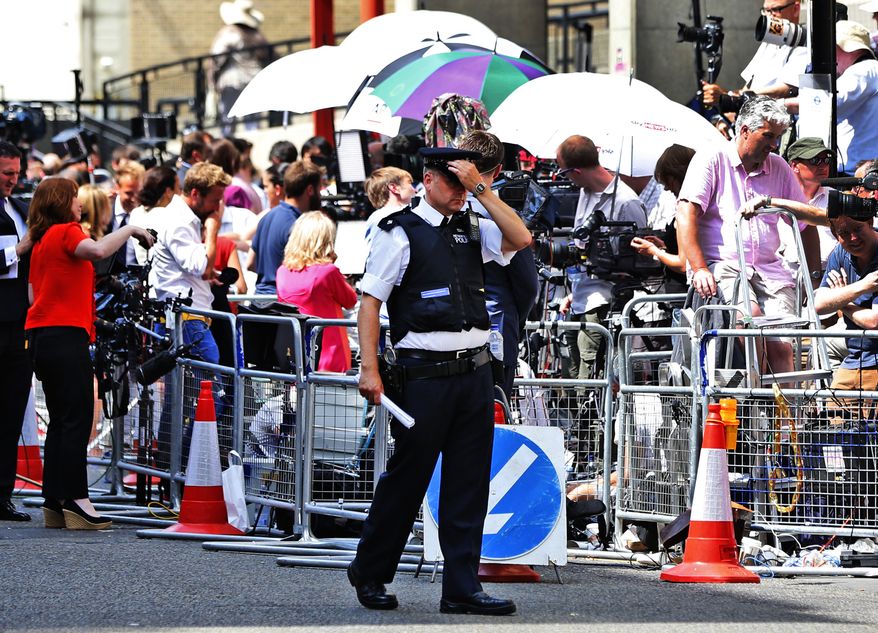 A British police, backdropped by members of the media, walks outside St. Mary's Hospital exclusive Lindo Wing in London, Monday, July 22, 2013. Buckingham Palace officials say Prince William's wife, Kate, has been admitted to the hospital in the early stages of labour. Royal officials said that Kate traveled by car to St. Mary's Hospital in central London. Kate _ also known as the Duchess of Cambridge _ is expected to give birth in the private Lindo Wing of the hospital, where Princess Diana gave birth to William and his younger brother, Prince Harry.The baby will be third in line for the British throne _ behind Prince Charles and William _ and is anticipated eventually to become king or queen.(AP Photo/Lefteris Pitarakis)