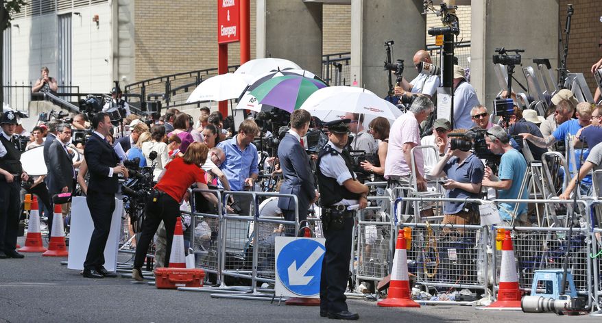 A British police officer, backdropped by members of the media, stands outside St. Mary's Hospital exclusive Lindo Wing in London, Monday, July 22, 2013. Buckingham Palace officials say Prince William's wife, Kate, has been admitted to the hospital in the early stages of labour. Royal officials said that Kate traveled by car to St. Mary's Hospital in central London. Kate _ also known as the Duchess of Cambridge _ is expected to give birth in the private Lindo Wing of the hospital, where Princess Diana gave birth to William and his younger brother, Prince Harry.The baby will be third in line for the British throne _ behind Prince Charles and William _ and is anticipated eventually to become king or queen.(AP Photo/Lefteris Pitarakis)
