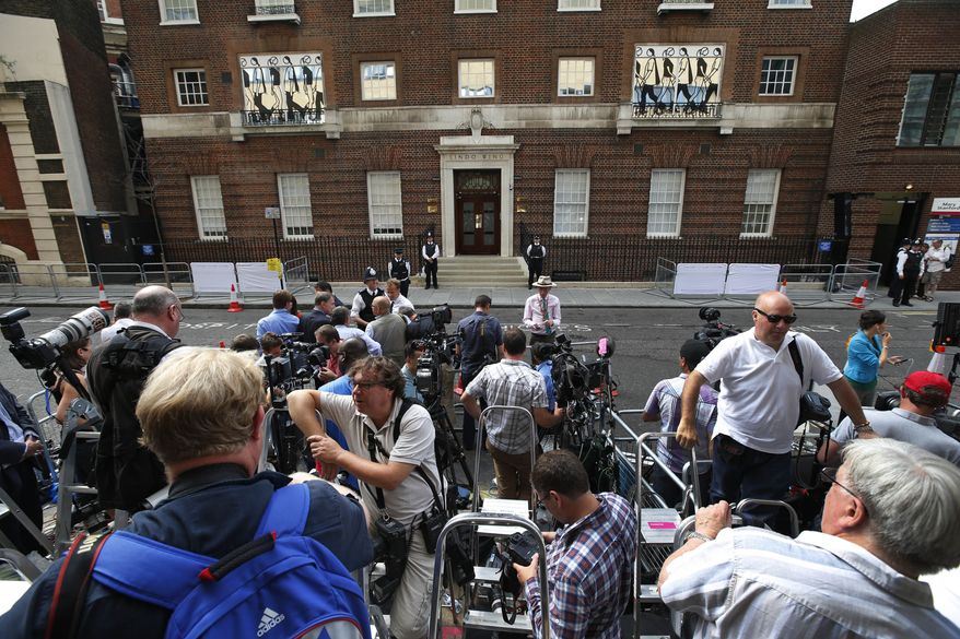 Members of the media wait across from St. Mary's Hospital exclusive Lindo Wing in London, Monday, July 22, 2013. Buckingham Palace officials say Prince William's wife, Kate, has been admitted to the hospital in the early stages of labour. Royal officials said that Kate traveled by car to St. Mary's Hospital in central London. Kate _ also known as the Duchess of Cambridge _ is expected to give birth in the private Lindo Wing of the hospital, where Princess Diana gave birth to William and his younger brother, Prince Harry. The baby will be third in line for the British throne _ behind Prince Charles and William _ and is anticipated eventually to become king or queen. (AP Photo/Lefteris Pitarakis)