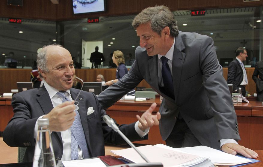 French Foreign Minister Laurent Fabius, left, talks with Slovenian Foreign Minister Karl Erjavec during the EU foreign ministers meeting at the European Council building in Brussels, Monday, July 22, 2013. (AP Photo/Yves Logghe)
