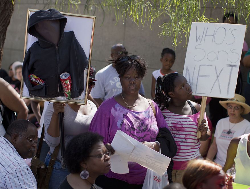 Demonstrators listen to comments outside the Lloyd George Federal Courthouse during a "Justice for Trayvon" rally on Saturday, July 20, 2013, in Las Vegas. (AP Photo/Julie Jacobson)