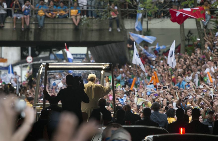 A crowd of faithful cheer as Pope Francis rides in his popemobile in Rio de Janeiro, Brazil, Monday, July 22, 2013. The pontiff arrived for a seven-day visit in Brazil, the world's most populous Roman Catholic nation. During his visit, Francis will meet with legions of young Roman Catholics converging on Rio for the church's World Youth Day festival. (AP Photo/Domenico Stinellis)