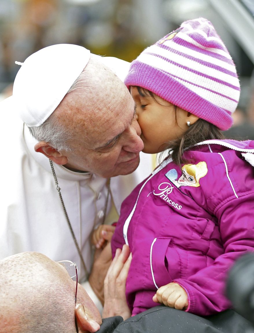 Pope Francis kisses a child as he arrives in his popemobile to the Aparecida basilica in Aparecida, Brazil, Wednesday, July 24, 2013. Tens of thousands of faithful flocked to the tiny town of Aparecida, tucked into an agricultural region halfway between Rio de Janeiro and Sao Paulo, where he is to celebrate the first public Mass of his trip in a massive basilica dedicated to the nation's patron saint. (AP Photo/Victor R. Caivano)