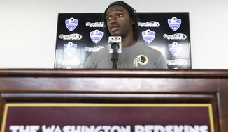 Washington Redskins quarterback Robert Griffin III answers reporters&#39; questions during a news conference at the team&#39;s new training facility in Richmond, Va. Wednesday, July 24, 2013. Griffin was recently cleared by doctors to begin practice at NFL football training camp which begins Thursday. (AP Photo/Steve Helber)