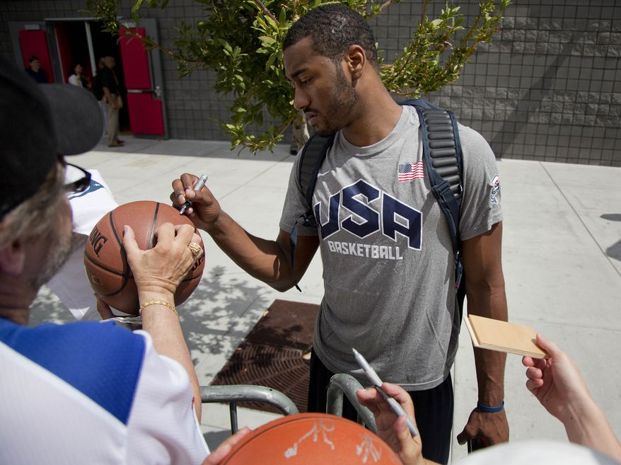 John Wall of the Washington Wizards signs autographs for fans after a USA Basketball mini camp practice, Monday, July 22, 2013, in Las Vegas. Twenty-eight of the best young players in the country are in Las Vegas for four days of workouts that essentially mark the kickoff of 2016 Olympic preparations. (AP Photo/Julie Jacobson)