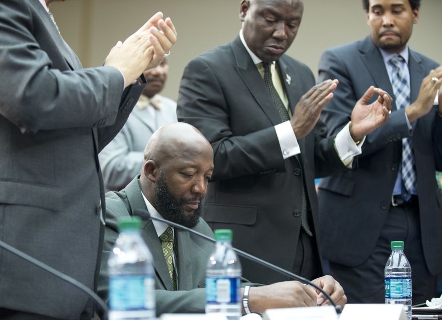 Tracy Martin, bottom, the father of slain 17-year old Trayvon Martin, looks down as the crowd give him an applause during a forum titled "The Status of Black Males: Ensuring Our Boys Mature Into Strong Men" on Capitol Hill Washington, Wednesday, July 24, 2013. (AP Photo/Manuel Balce Ceneta)