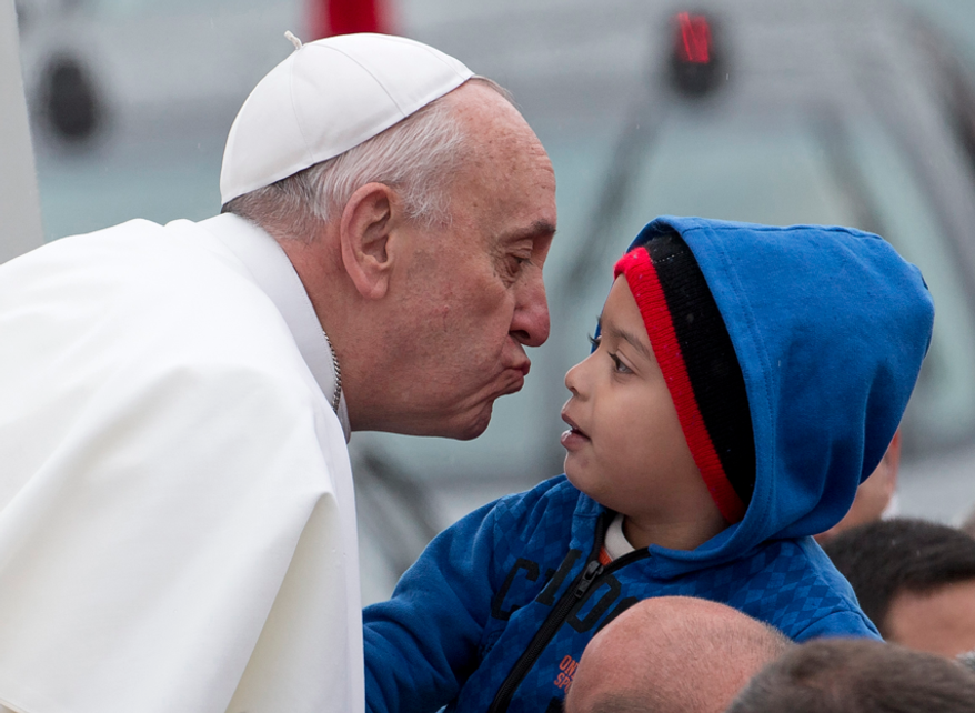 Pope Francis reaches out to kiss a child as he arrives to the Aparecida Basilicia in Aparecida, Brazil, Wednesday, July 24, 2013. (AP Photo/Domenico Stinellis)