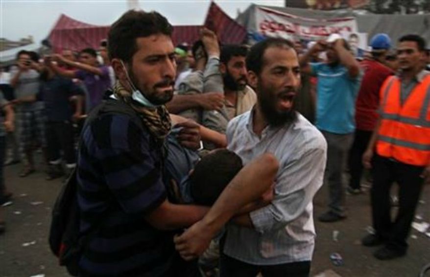 Supporters of Egypt's ousted President Mohammed Morsi carry an injured man to a field hospital following clashes with security forces at Nasr City, where pro-Morsi protesters have held a weekslong sit-in, in Cairo, Egypt, Saturday, July 27, 2013. Police fired tear gas to disperse hundreds of Morsi supporters, setting off clashes that lasted for hours and left tens of people dead. (AP Photo/Khalil Hamra)