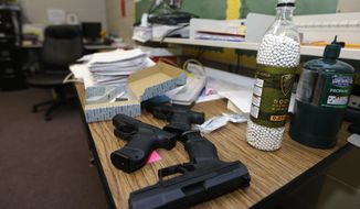 **FILE** Practice air-powered handguns sit on a teacher&#39;s desk in a classroom at Clarksville High School in Clarksville, Ark., on July 11, 2013. Twenty Clarksville School District staff members are training during the summer to be armed security guards on campus. (Associated Press)