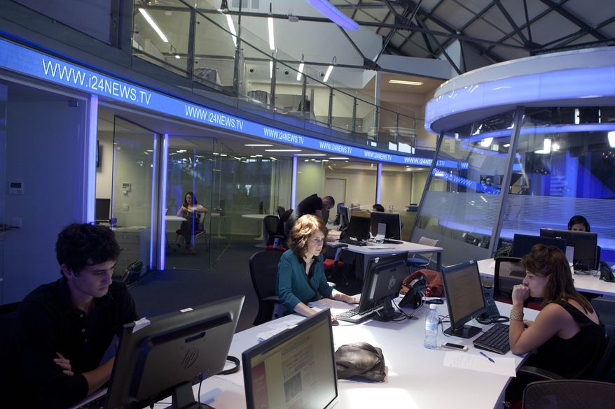 In this Sunday, July 28, 2013 photo, journalists work inside a studio of the new television channel I24news in Tel Aviv, Israel. (AP Photo/Dan Balilty)
