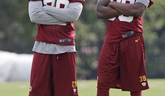 Washington Redskins safety Bacarri Rambo (29) and cornerback David Amerson watch during the morning practice at the NFL football teams training camp in Richmond, Va., Wednesday, July 31, 2013. (AP Photo/Steve Helber)