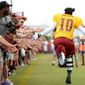Washington Redskins quarterback Robert Griffin III (10) gets high fives from fans as he runs the length of the field before afternoon practice at the Bon Secours Washington Redskins Training Center, Richmond, Va., Tuesday, July 30, 2013. (Andrew Harnik/The Washington Times)