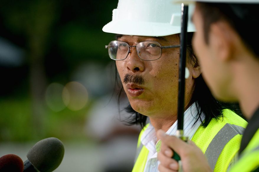 Chinese sculptor Lei Yixin gives an update Thursday on his work to remove a controversial "drum major" quote off the side of the Martin Luther King Jr. Memorial near the Tidal Basin.
(Andrew Harnik/The Washington Times)