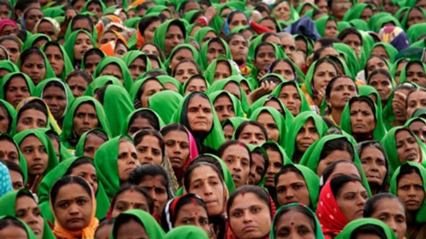 ** FILE ** Indian women look on during Gujarat Chief Minister Narendra Modi’s fast in Godhra, about 140 kilometers (87 miles) from Ahmedabad, India, Jan. 20, 2012. (Associated Press)