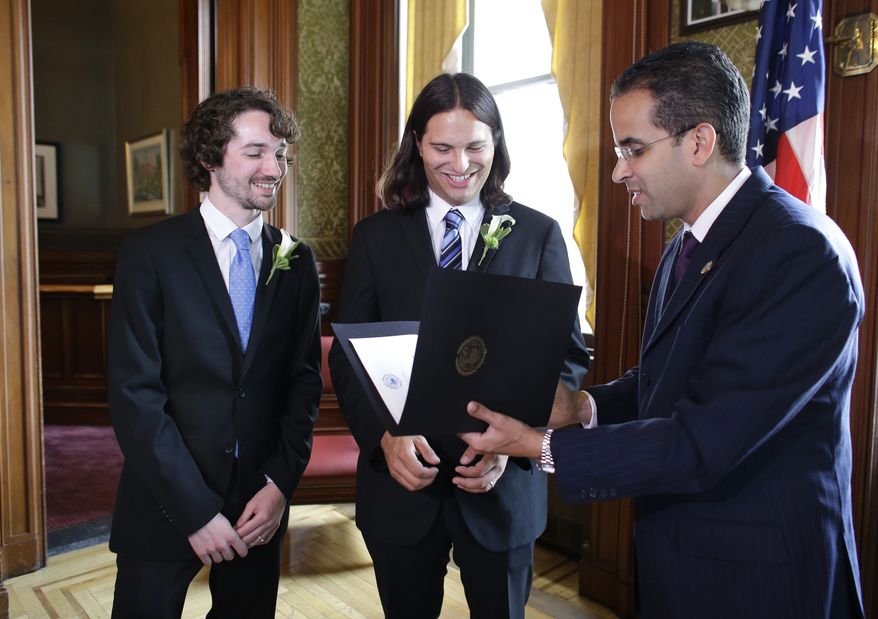 Gary McDowell, left, and Zachary Marcus, center, both of Providence, R.I., are presented with their signed marriage license by Providence Mayor Angel Taveras, right, at City Hall, in Providence, Thursday, Aug. 1, 2013, moments after Taveras presided over the couples marriage ceremony. Gay marriage became legal in Rhode Island and Minnesota at 12:01 a.m. Thursday. (AP Photo/Steven Senne)