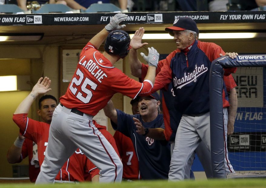 Adam LaRoche returns to the dugout Saturday night after hitting a home run using Jayson Werth's bat. The Washington Nationals beat the MIlwaukee Brewers 3-0. (Associated Press photo)