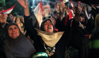 Supporters of Egypt&#x27;s ousted President Mohammed Morsi chant slogans during a protest outside Rabaah al-Adawiya mosque, where protesters have installed a camp and hold daily rallies at Nasr City in Cairo, Egypt, Sunday, Aug. 4, 2013. (AP Photo/Khalil Hamra)