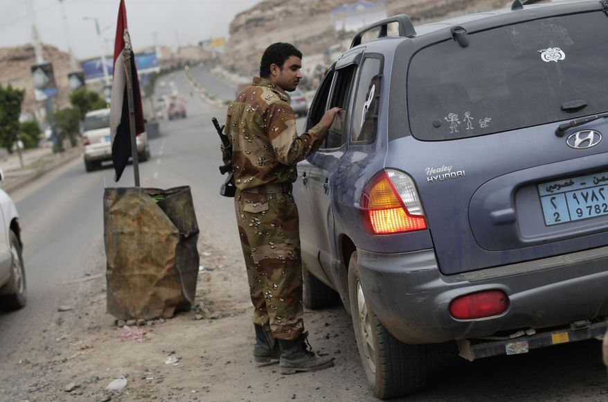 A Yemeni soldier inspects a car at a checkpoint on a street leading to the U.S. embassy in Sanaa, Yemen, Sunday, Aug. 4, 2013. Security forces close access roads, put up extra blast walls and beef up patrols near some of the 21 U.S. diplomatic missions in the Muslim world that Washington ordered closed for the weekend over a "significant threat'' of an al Qaeda attack. (AP Photo/Hani Mohammed)
