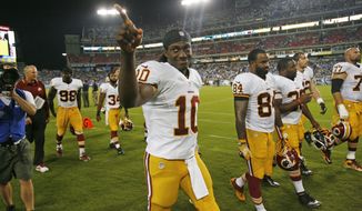 Washington Redskins quarterback Robert Griffin III (10) acknowledges a fan as he walks to the locker room for halftime during a preseason NFL football game against the Tennessee Titans on Thursday, Aug. 8, 2013, in Nashville, Tenn. (AP Photo/Mark Zaleski)