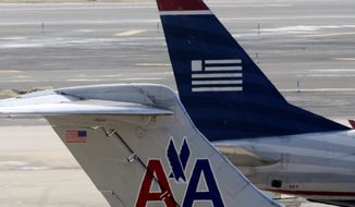 **FILE** American Airlines and US Airways jets prepare for flight at a gate at the Philadelphia International Airport on Feb. 14, 2013. (Associated Press)