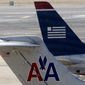**FILE** American Airlines and US Airways jets prepare for flight at a gate at the Philadelphia International Airport on Feb. 14, 2013. (Associated Press)