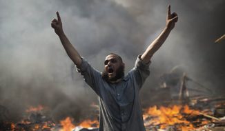 A supporter of ousted Islamist President Mohammed Morsi shouts during clashes with Egyptian security forces in Cairo&#39;s Nasr City district, Egypt, Wednesday, Aug. 14, 2013. Egyptian police in riot gear swept in with armored vehicles and bulldozers Wednesday to clear two sprawling encampments of supporters of the country&#39;s ousted Islamist president in Cairo, showering protesters with tear gas as the sound of gunfire rang out. (AP Photo/Manu Brabo)