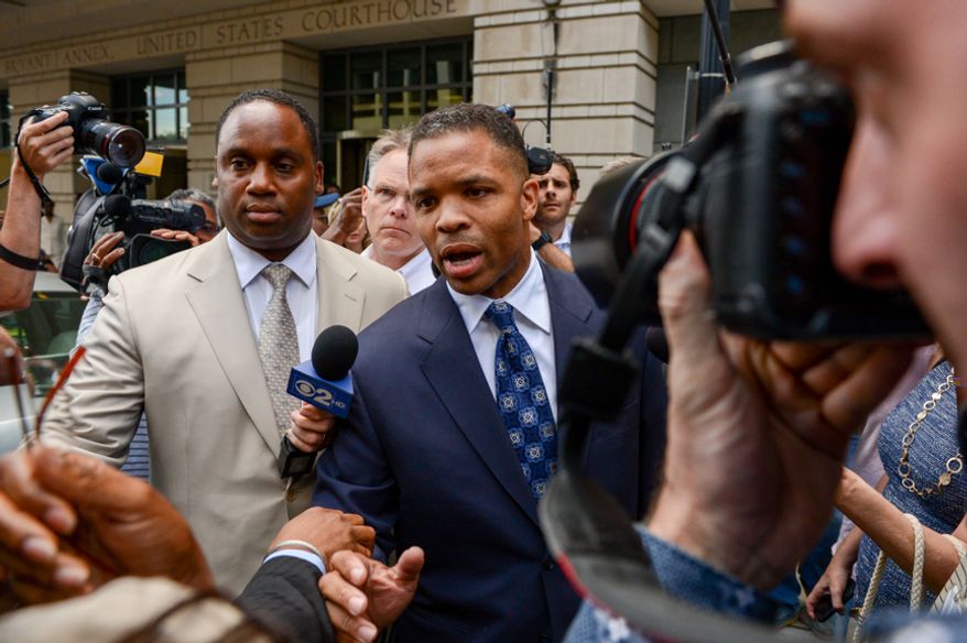 ** FILE ** Former Illinois Rep. Jesse Jackson Jr. (center) leaves a D.C. federal court on Aug. 14, 2013, after being sentenced to 30 months in prison for stealing money from his own campaign. (Andrew Harnik/The Washington Times)