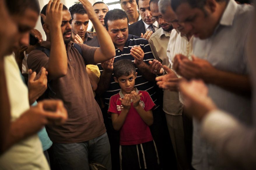 A son of the late Ammar Badie prays during his father's funeral in al-Hamed mosque in Cairo's Katameya district on Aug. 18, 2013. Badie, the son of Muslim Brotherhood's spiritual leader Mohammed Badie, was killed by Egyptian security forces two days earlier during clashes in Cairo's Ramses Square. (Associated Press)
