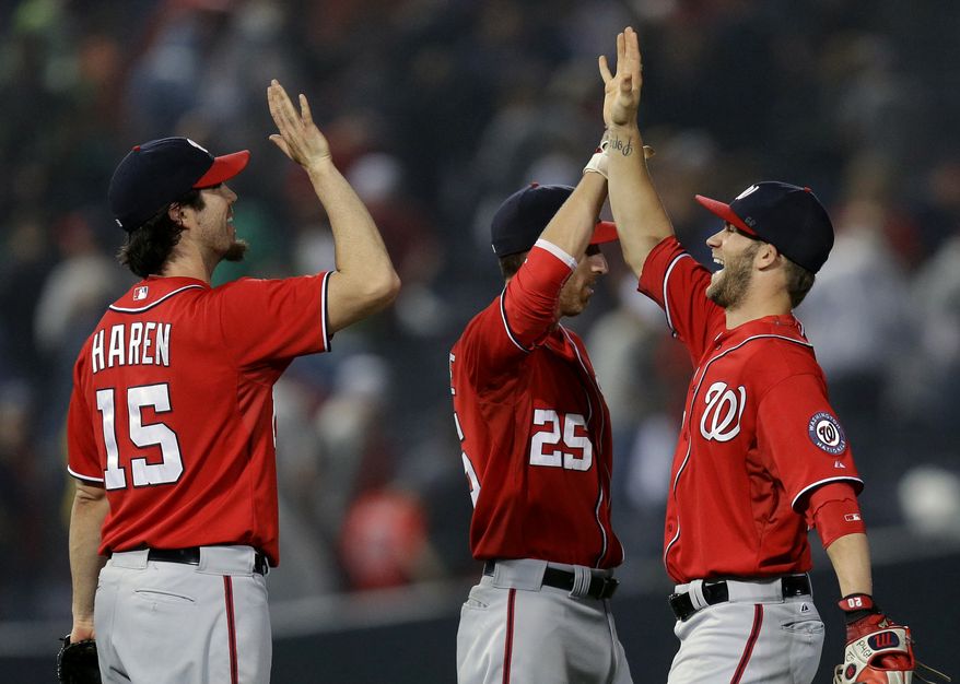 The Washington Nationals celebrate after defeating the Braves in an epic 15-inning affair that lasted five hours and 29 minutes. (Associated Press Photo)