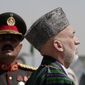 Afghan President Hamid Karzai (foreground) inspects the guard of honor during Independence Day celebrations at the Defense Ministry in Kabul, Afghanistan, on Monday, Aug 19, 2013. Mr. Karzai and Cabinet members attended a parade on Monday to mark the event, which commemorates the day Afghanistan signed a treaty with Britain in 1919 making it independent. (AP Photo/Rahmat Gul)