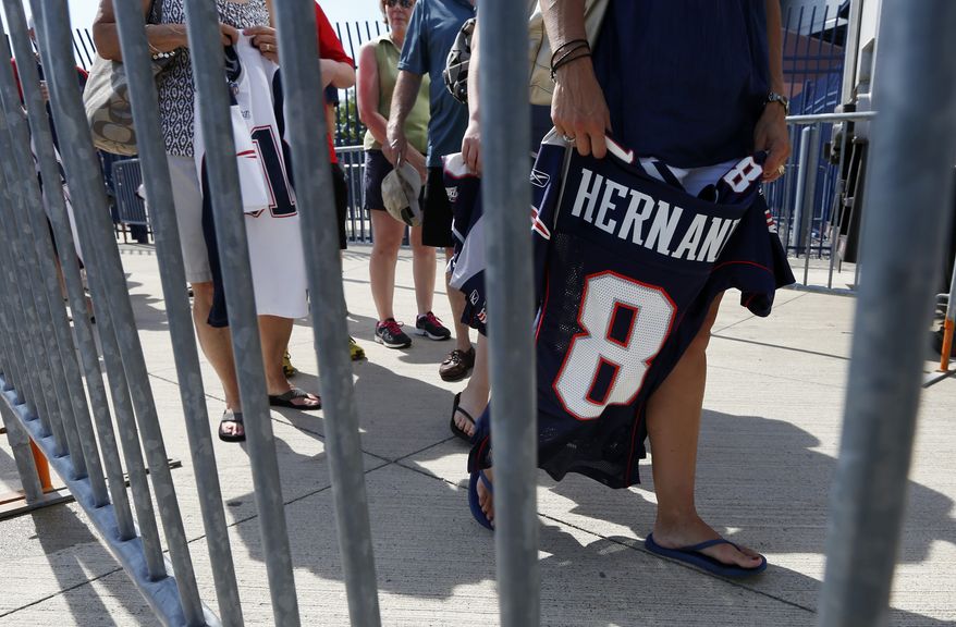 Fans line up behind a barrier to exchange their New England Patriots Aaron Hernandez football jerseys at Gillette Stadium in Foxborough, Mass., Saturday, July 6, 2013. The Patriots are offering a new jersey to all fans who want to get rid of the one they bought with Hernandez's name on it. (AP Photo/Michael Dwyer)