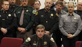 **FILE** Weld County Sheriff John Cooke (center), backed by a group of fellow sheriffs, testifies against proposed gun control legislation in the Colorado Legislature, at the State Capitol in Denver on March 4, 2013. State Senate committees began work on a package of gun-control measures that already have cleared the House which include limits on ammunition magazine sizes and expanded background checks to include private sales and online purchases. (Associated Press)