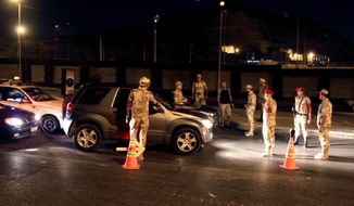** FILE ** Egyptian army forces search vehicles at a checkpoint during curfew in the Nasr City section of Cairo on Monday, Aug. 19, 2013. The capital remained under a state of emergency and a dusk-to-dawn curfew. (AP Photo/Ahmed Gomaa)