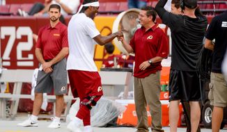 Washington Redskins quarterback Robert Griffin III (10), center left, greets Washington Redskins owner Dan Snyder, center right, during warm ups before the Washington Redskins play the Pittsburgh Steelers in NFL preseason football at FedEx Field, Landover, Md., Monday, August 19, 2013. (Andrew Harnik/The Washington Times)