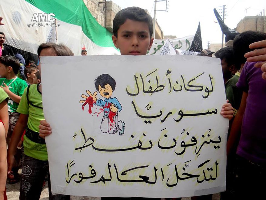 A citizen journalism image provided by Aleppo Media Center, authenticated based on its contents and other AP reporting, shows a Syrian boy holding an Arabic placard that reads: "if Syria's children bled petrol, the entire world would have intervened," during a demonstration against the alleged chemical weapons attack at the suburbs of Damascus, in Aleppo on Aug. 21, 2013. Syrian anti-government activists accused the regime of carrying out a toxic gas attack that killed at least 100 people, including many children as they slept, during intense artillery and rocket barrages on the eastern suburbs of Damascus, part of a fierce government offensive in the area. (Associated Press/Aleppo Media Center)
