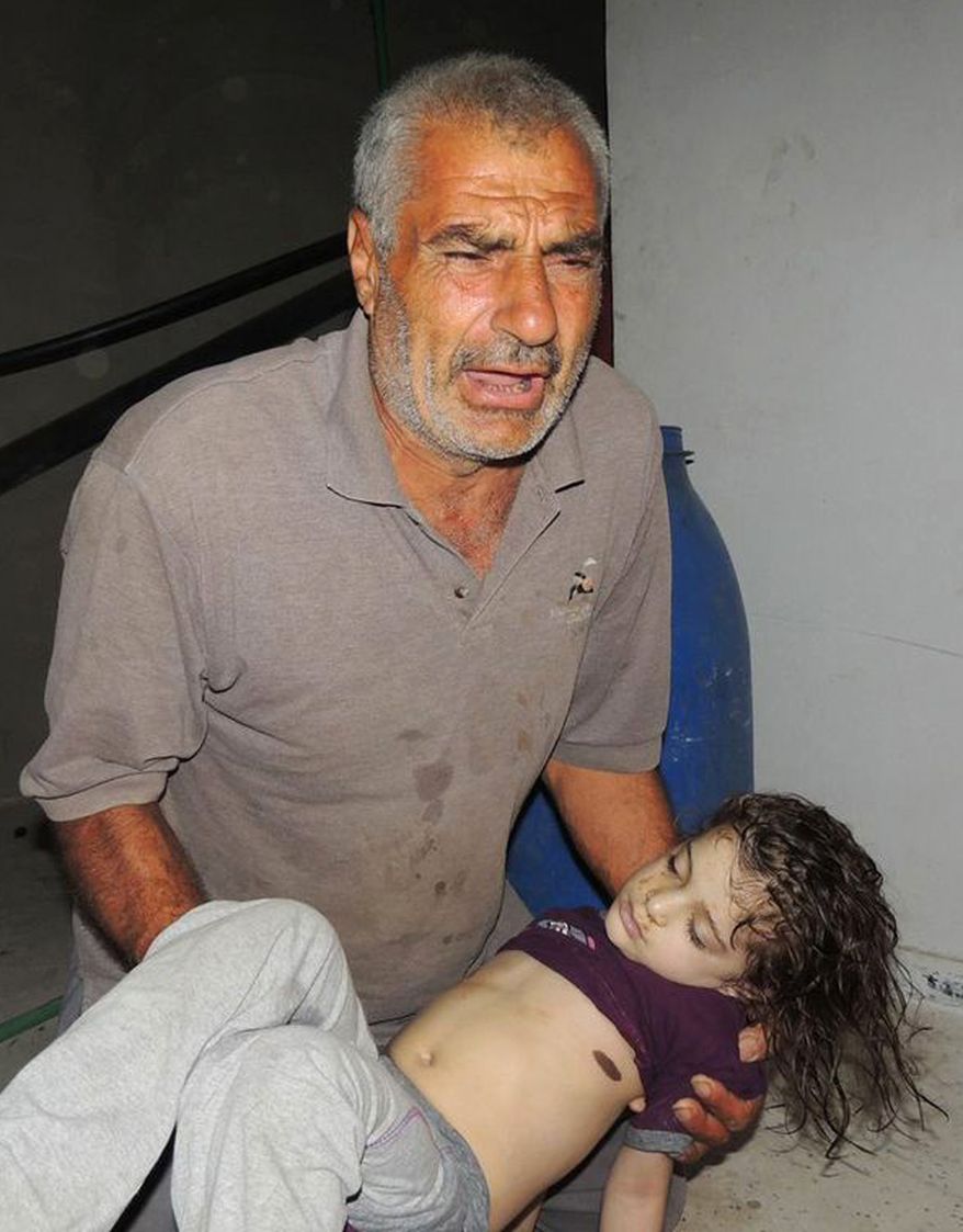 This citizen journalism image provided by the Local Committee of Arbeen, authenticated based on its contents and other AP reporting, shows a Syrian man reacts as he carries a dead body of a Syrian girl after an alleged poisonous gas attack fired by regime forces, according to activists in Arbeen town of Damascus on Aug. 21, 2013. Syrian anti-government activists accused the regime of carrying out a toxic gas attack that killed at least 100 people, including many children as they slept, during intense artillery and rocket barrages on the eastern suburbs of Damascus, part of a fierce government offensive in the area. (Associated Press/Local Committee of Arbeen)